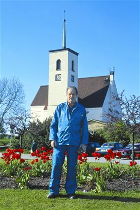Kyrkvaktmästare Harry Johansson står framför kyrkan i Kallinge 1991.